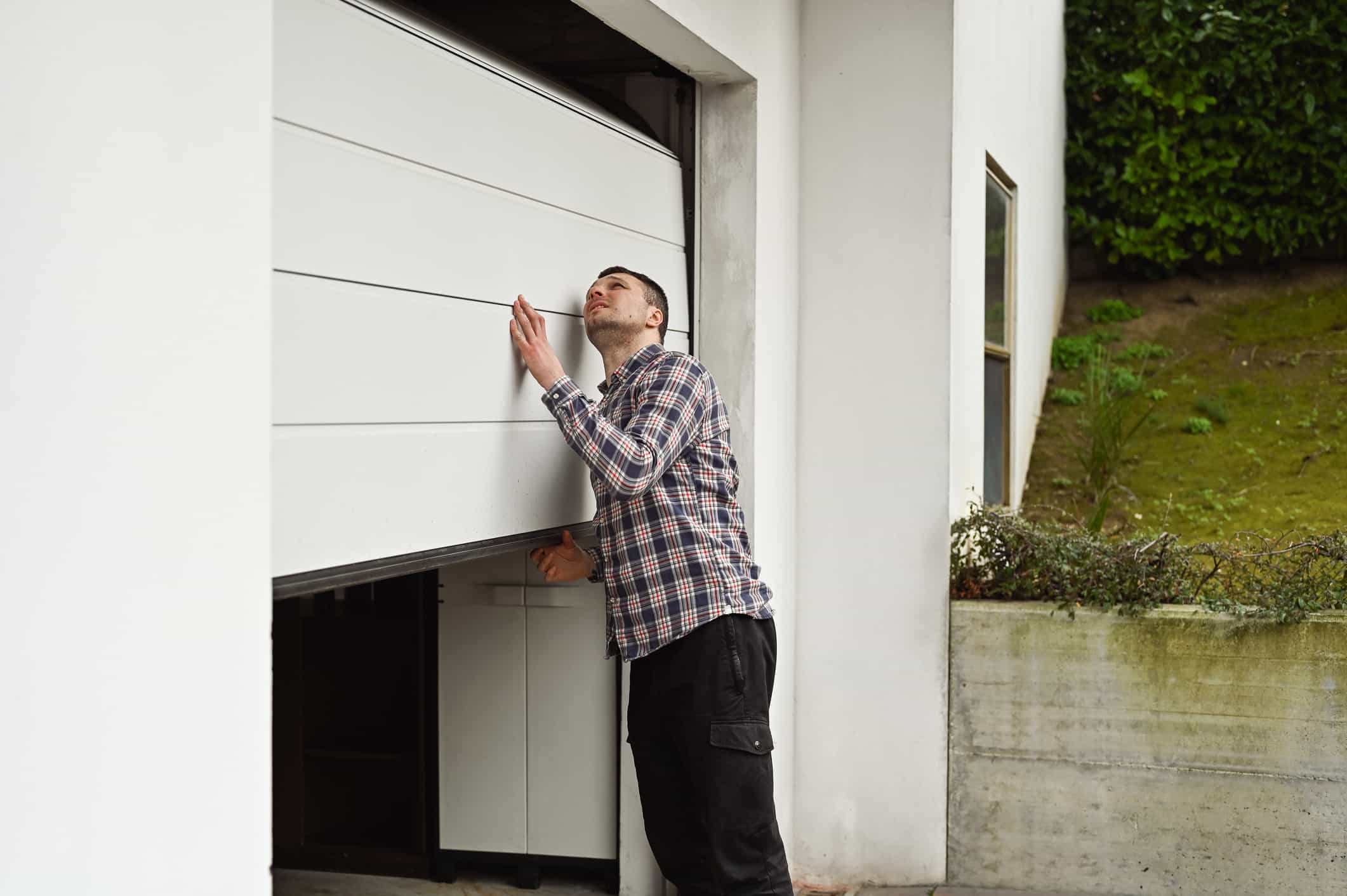 Man Checking the Broken Garage Door